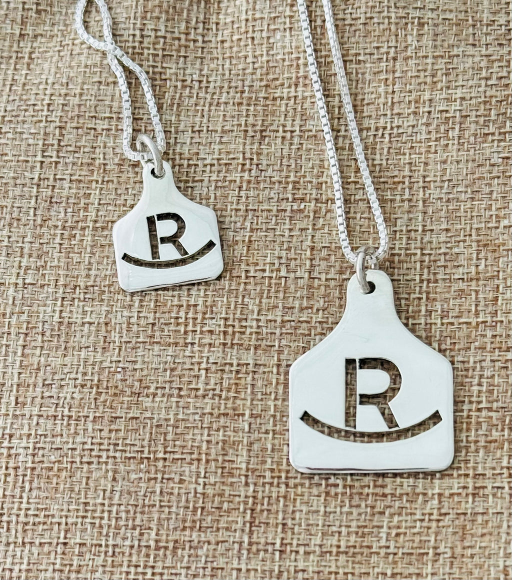 Two sterling silver ear tag necklaces with an R ranch brand, in two sizes on ball chain